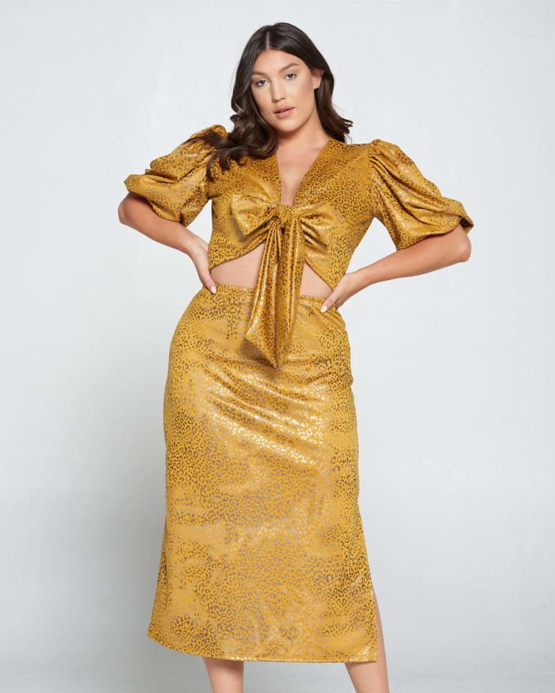 Front of a model wearing a size 1X Cheetah Wrap Top and Skirt Set in Mustard Foil Cheetah by L I V D. | dia_product_style_image_id:241699